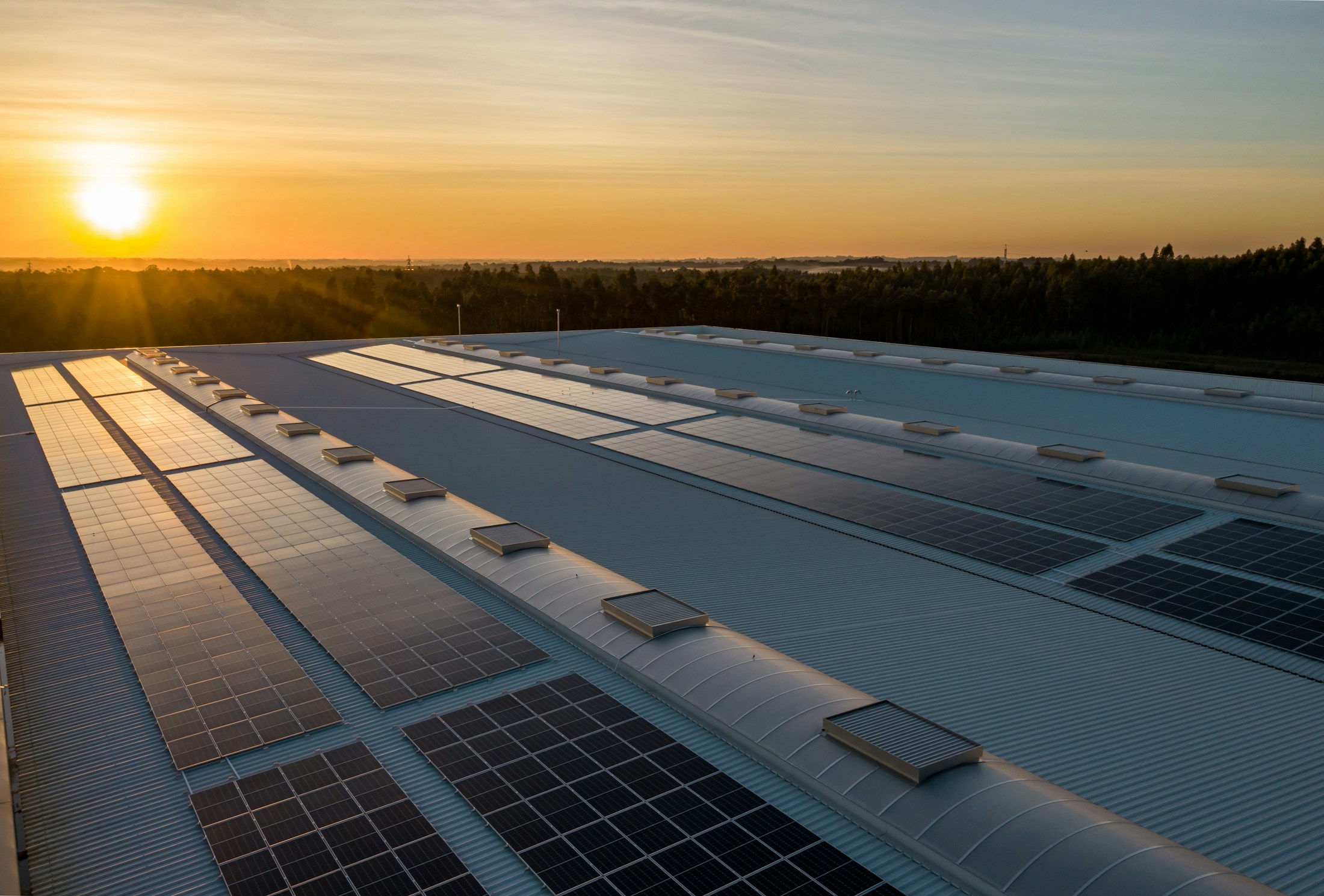 Referência ilustrativa de módulos solares sobre cobertura; não representa uma obra específica da Coenma